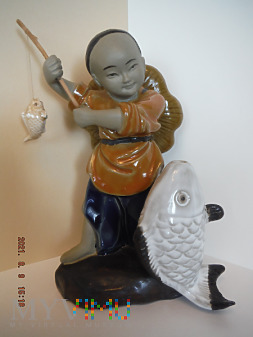 młody chińczyk z małą i wielką, białą rybą